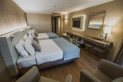 a hotel room with two beds and a desk at Enotel Lido - All Inclusive in Funchal