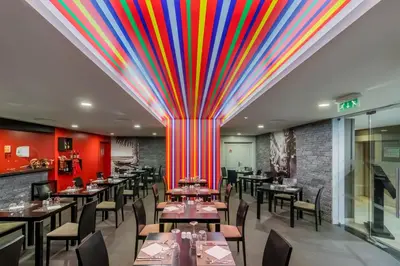 a restaurant with a colorful ceiling with tables and chairs at Enotel Lido - All Inclusive in Funchal