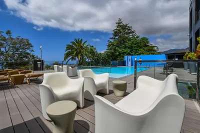 a bunch of lounge chairs and umbrellas on a deck at Quinta Mirabela - Design Hotel in Funchal