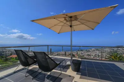 a view from the top of a building with chairs and umbrellas at Quinta Mirabela - Design Hotel in Funchal