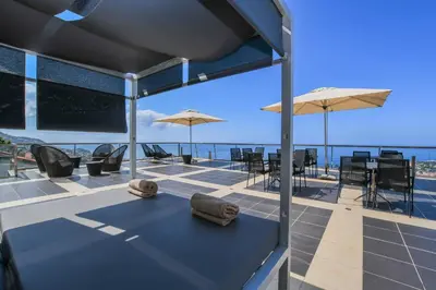 a group of tables and chairs with an umbrella at Quinta Mirabela - Design Hotel in Funchal