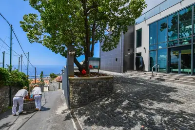 a couple of men working on a statue in front of a building at Quinta Mirabela - Design Hotel in Funchal