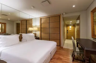 a bedroom with a large white bed and a desk at Royal Savoy - Ocean Resort - Savoy Signature in Funchal