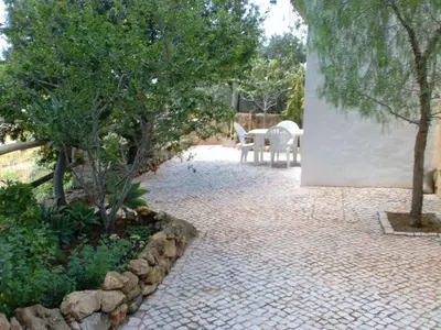 a patio with a table and chairs and trees at Quinta dos Caracois in Lagos