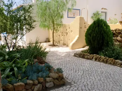 a garden with a stone path and trees and a building at Quinta dos Caracois in Lagos