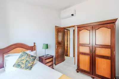 a bedroom with a bed and a wooden closet at Casa da Avó in Espiche
