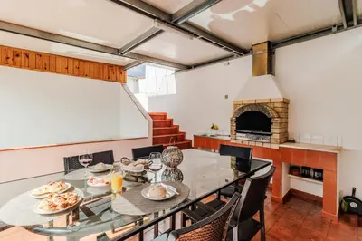 a dining room with a table and a fireplace at Casa da Avó in Espiche