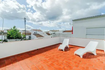 a balcony with two white chairs on a roof at Casa da Avó in Espiche