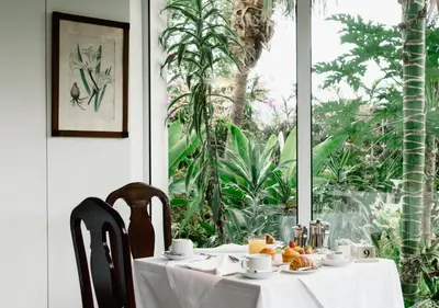 a table with a white table cloth on it with a window at Quintinha Sao Joao Hotel & Spa in Funchal
