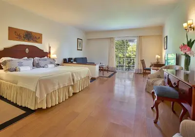 a bedroom with a large bed and a living room at Quintinha Sao Joao Hotel & Spa in Funchal