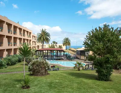 a resort with a pool and a gazebo next to a building at Dom Pedro Garajau in Caniço