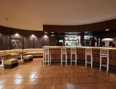 a bar in a restaurant with stools at Dom Pedro Madeira in Machico