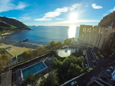a view of a body of water with a building at Dom Pedro Madeira in Machico