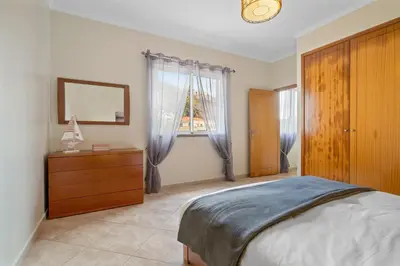 a bedroom with a bed and a dresser and a window at Sunny Ponta 