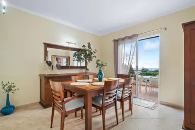 a dining room with a table and chairs and a mirror at Sunny Ponta 