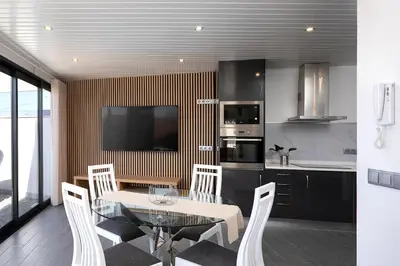 a kitchen with a table and chairs and a television at ANGEL´S SUNSET in Estreito da Calheta