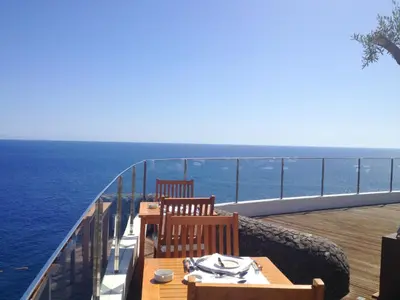 a table and two chairs on a balcony overlooking the ocean at Madeira Regency Cliff - Adults Only in Funchal