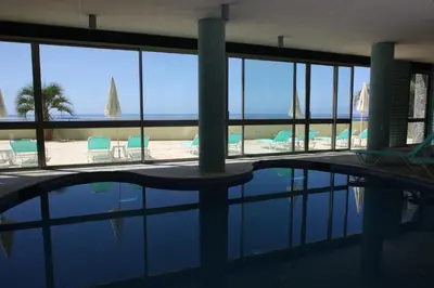 a swimming pool with chairs and a view of the ocean at Madeira Regency Cliff - Adults Only in Funchal