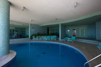 a large swimming pool in a hotel with blue chairs at Madeira Regency Cliff - Adults Only in Funchal