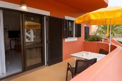 a patio with a table and an umbrella at Villa Mar Azul in Lagos