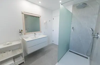 a white bathroom with a sink and a shower at Villa Mar Azul in Lagos