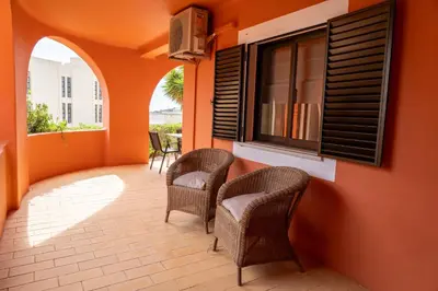 a balcony with wicker chairs and a window at Villa Mar Azul in Lagos