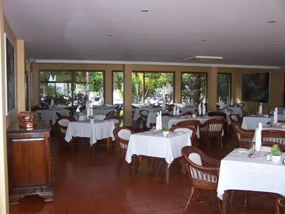 a restaurant with tables and chairs with white table cloth at Hotel Porto Santo & Spa in Porto Santo