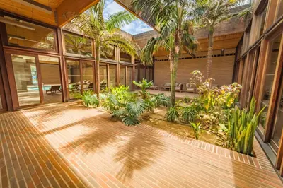 a courtyard with palm trees and plants in a building at Hotel Porto Santo & Spa in Porto Santo