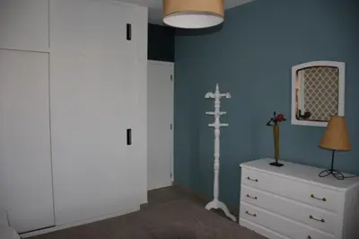 a bedroom with a white dresser and a blue wall at Porto Santo Apartment in Porto Santo