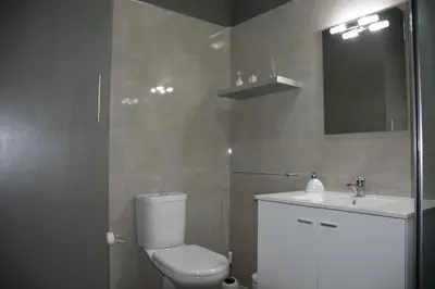 a bathroom with a toilet and a sink and a mirror at Porto Santo Apartment in Porto Santo