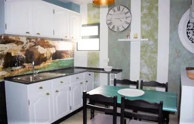 a kitchen with a table and a clock on the wall at Porto Santo Apartment in Porto Santo