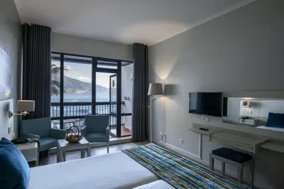 a bedroom with a large bed and large windows at Estalagem do Mar in São Vicente