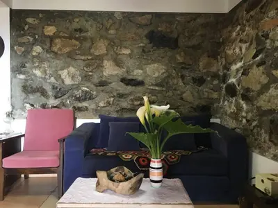 a living room with a blue couch and a pink chair at Casa d'Olívia in Porto da Cruz