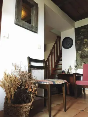 a room with a chair and a table and stairs at Casa d'Olívia in Porto da Cruz