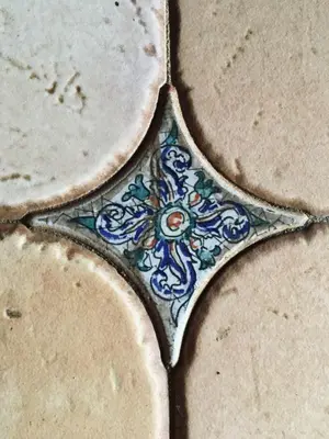 a close up of a tile with a flower on it at Casa d'Olívia in Porto da Cruz