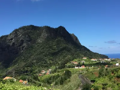 a mountain with a village on the side of it at Casa d'Olívia in Porto da Cruz
