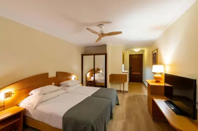 a bedroom with a bed and a ceiling fan at Pestana Ocean Bay Resort in Funchal