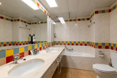 a bathroom with two sinks and a tub and a toilet at Pestana Ocean Bay Resort in Funchal