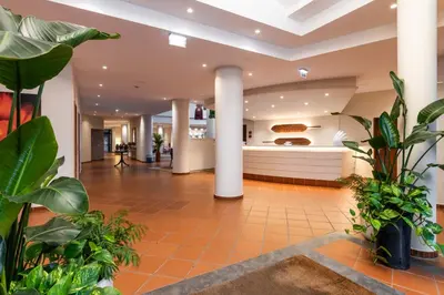 a lobby with plants and a kitchen in the background at Pestana Ocean Bay Resort in Funchal