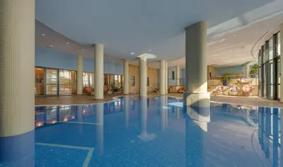 a large swimming pool in a building with columns at Pestana Grand Ocean Resort Hotel in Funchal