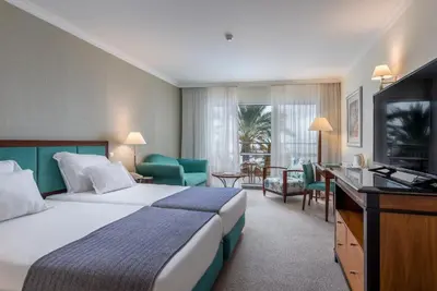 a hotel room with a bed and a flat screen tv at Pestana Grand Ocean Resort Hotel in Funchal