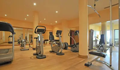 a gym with a bunch of exercise equipment in it at Pestana Grand Ocean Resort Hotel in Funchal