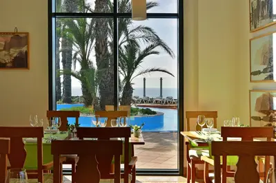 a dining room with a table and a view of the ocean at Pestana Grand Ocean Resort Hotel in Funchal