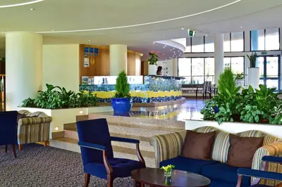 a lobby with couches and plants in a building at Pestana Grand Ocean Resort Hotel in Funchal
