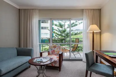 a living room with a couch and a table and a window at Pestana Grand Ocean Resort Hotel in Funchal