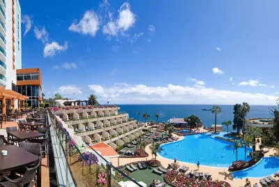 a large building with a large purple sign on it at Pestana Carlton Madeira Ocean Resort Hotel in Funchal