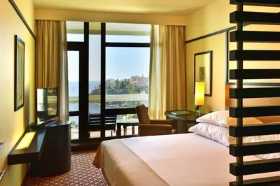 a hotel room with a bed and a balcony at Pestana Casino Park Hotel & Casino in Funchal
