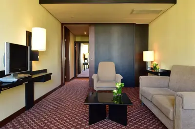 a living room with a couch and a tv at Pestana Casino Park Hotel & Casino in Funchal