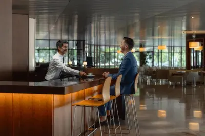 two men standing at a bar in a restaurant at Pestana Casino Park Hotel & Casino in Funchal