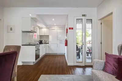 a kitchen and living room with white cabinets at Quinta da Tia Briosa by Homie in Ponta do Sol